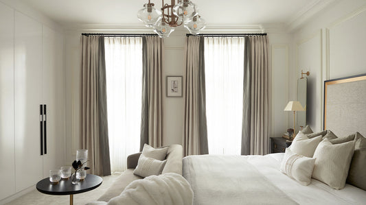Bedroom with gray curtains layered over sheers on a double curtain rod