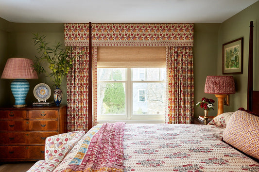 Bedroom with red patterned curtains and a matching board-mounted valance