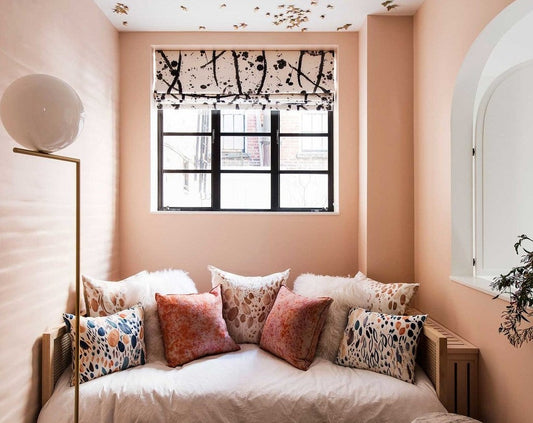 Pink daybed nook with a black and white printed blackout roman shade